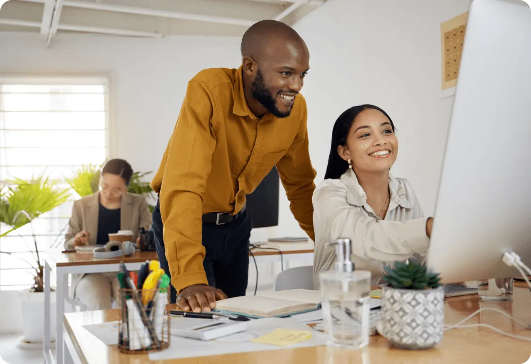 Two young professionals reviewing something on a monitor