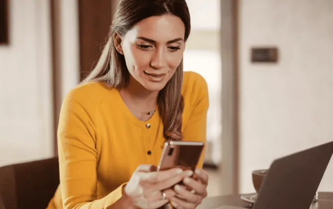 A woman using the RingCentral app on her cellphone and laptop